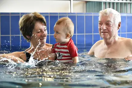 Grandparents et bébé profitent du lagune d'eau chaude