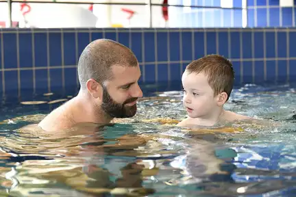 Papa et enfant profitent du lagune d'eau chaude