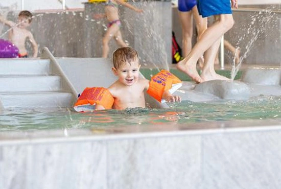 LAGO enfant avec des brassards dans la piscine